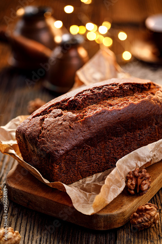 Homemade gingerbread on a baking paper on a rustic wooden table, close-up . Delicious dessert.