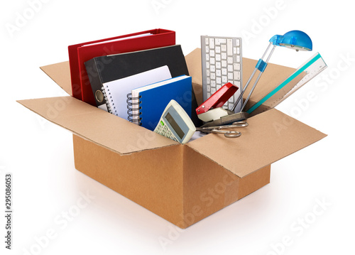 Cardboard moving box filled with office supplies, isolated on white background. Contains clipping path.