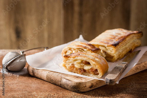 Traditional homemade apple strudel on brown background