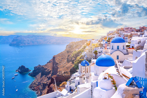 Piękny miasteczko Oia na wyspie Santorini, Grecja. Tradycyjna biała architektura i greckie cerkwie z niebieskimi kopułami nad kalderą na Morzu Egejskim. Malownicze tło podróży.