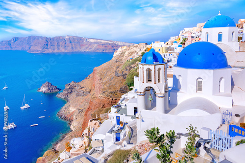 Piękny miasteczko Oia na wyspie Santorini, Grecja. Tradycyjna biała architektura i greccy ortodoksyjni kościół z błękitnymi kopułami nad kalderą w morzu egejskim, Grecja. Malownicze tło podróży.