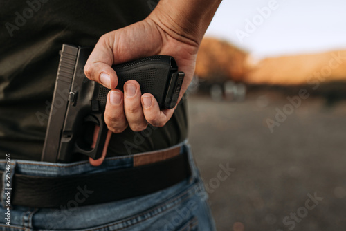 Man holding hidden short gun in his hand.