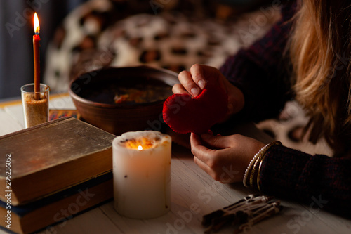 Red heart in hands of witch, love spell and broken heart, unrequited love. Psychic vision, fortune teller.