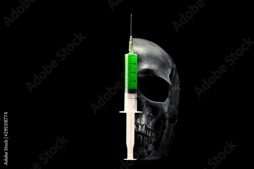 Skull and syringe with green liquid on a black background. 