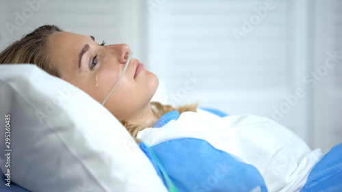Crying woman with oxygen nasal catheter, worrying before important operation