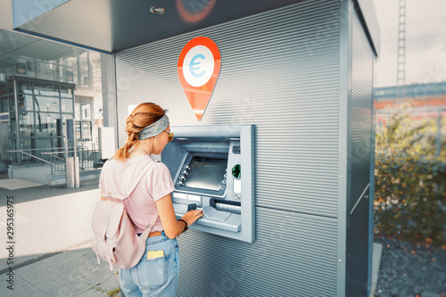 Asian woman withdraws money and pays the credit for study at the street European ATM self-service macine