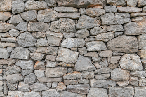 Stone wall texture background - grey stone siding with different sized stones 