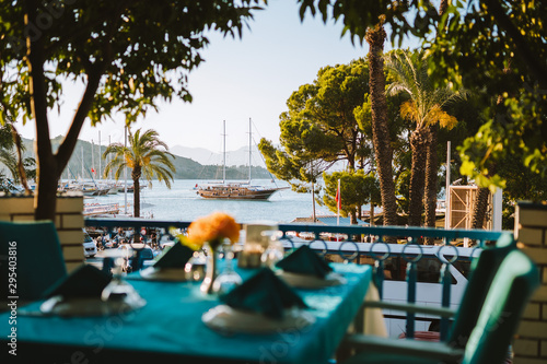A Turkish dinner table set with the harbour, yachts and traditional gulets in the background. Fethiye dock, Turkey. 