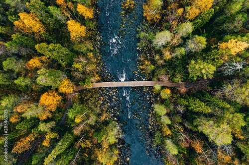 Widok z lotu ptaka na szybki przepływ rzeki przez skały i kolorowy las. Jesień w Finlandii