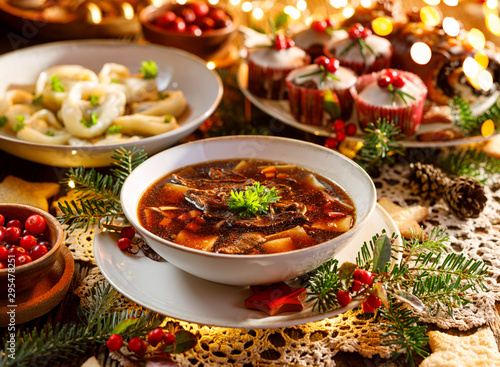 Christmas mushroom soup, a traditional vegetarian mushroom soup made with dried forest mushrooms in a ceramik plate on a festive table. Polish Christmas dinner
