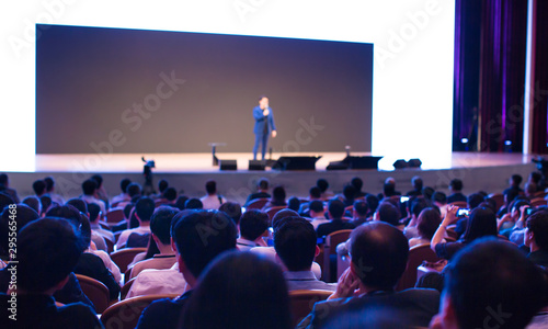 Seminar presenter at corporate conference giving speech. Speaker giving lecture to business audience. Entrepreneur forum executive manager leading discussion in hall during company training event. 