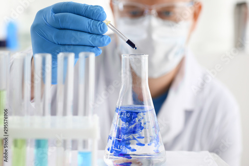 A male chemist holds test tube of glass