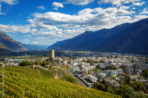 Terraced vineyards above Martigny in Valais Switzerland with medieval castle and Rhône valley.
