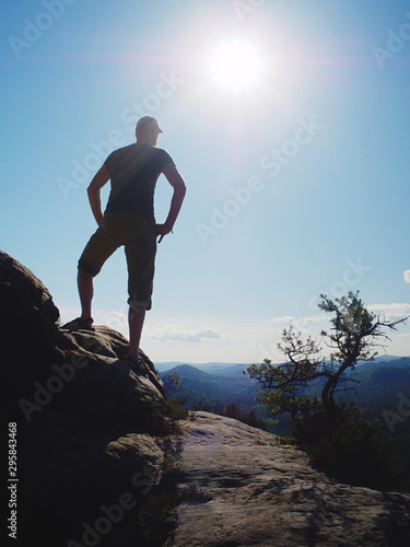 Tall guy with hand in akimbo pose standing and watch horizon