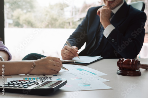 Consultation between business and lawyer about the tax laws discussing a contract agreement to pay taxes economically to the government in accordance with the national law.