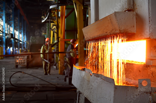 Steel quenching at high temperature in industrial furnace at the workshop of a forge plant. Process of cooling, heat treatmen. Blacksmith and metallurgical industry, steelmaking, hot rolling mill