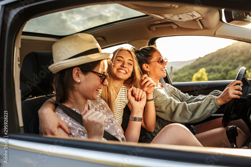 Group of best female friends travel together.They drives a car and having fun.Summer adventure.