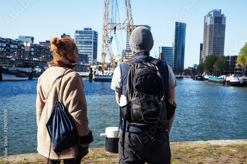 Young couple tourists looking and pointing to Rotterdam city harbour, future architecture concept, industrial lifestyle people