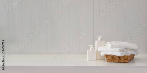 Towels with spa accessories on white table with copy space