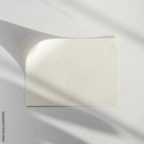 White background with a white blank of paper with its shadow
