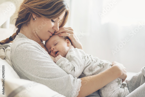 Loving mom carying of her newborn baby at home