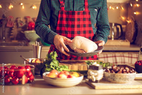 Mann bereitet leckeres und gesundes Essen in der häuslichen Küche zu Weihnachten zu (Weihnachtsente oder gans)