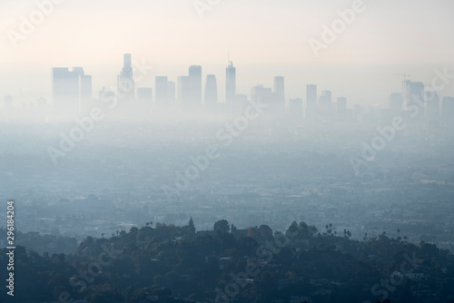Thick layer of smog and haze from nearby brush fire obscuring the view of downtown Los Angeles buildings in Southern California. Shot from hilltop in popular Griffith Park. 