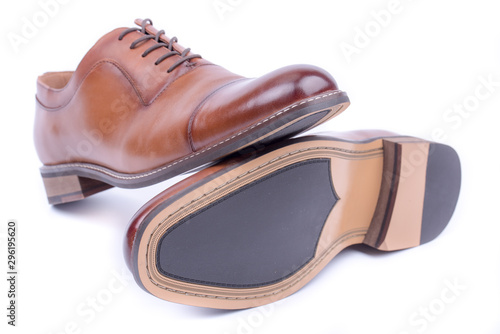 Shoes bottom, sole. Classic leather elegant shoe on a white background. Beautiful brown luxury and casual leather men shoes. Fashion accessory. Front view.Both legs on the ground. Isolated. Overturned