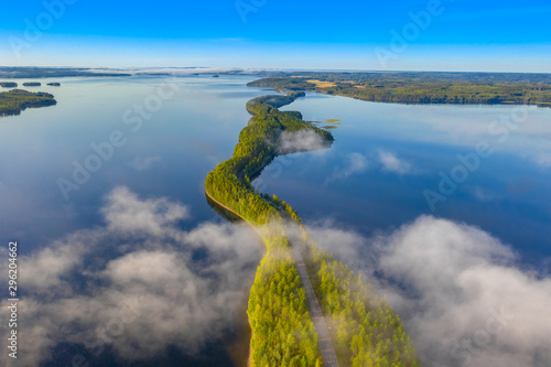 Aerial view of Pulkkilanharju Ridge, Paijanne National Park, southern part of Lake Paijanne. Landscape with drone. Fog, Blue lakes, fields and green forests from above on a sunny summer morning.