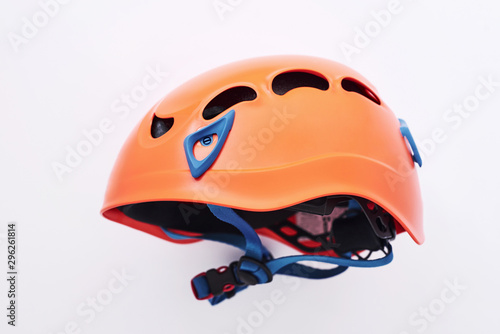 Side view. Isolated photo of climbing equipment - orange colored protective helmet