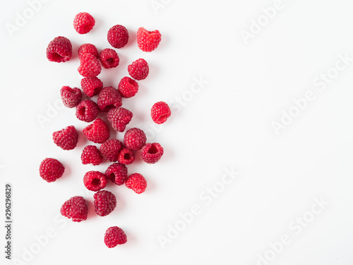Heap of fresh ripe red raspberries on white background. Raspberry with copy space for text or design. Top view or flat lay.
