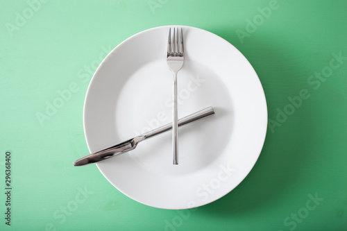 concept of intermittent fasting and ketogenic diet, weight loss. fork and knife crossed on a plate