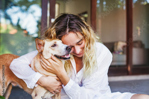 Beautiful caucasian woman hugging her mongrel dog pet