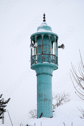 old wooden minaret in winter day