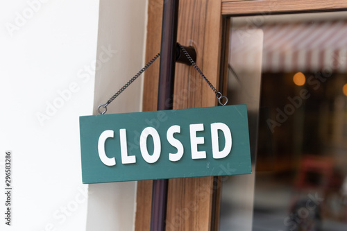 sorry we are closed sign hanging outside a restaurant, store, office or other