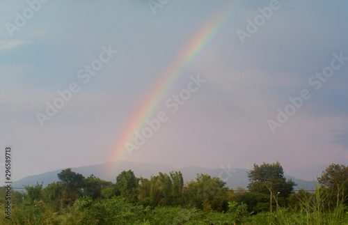Nature rainbow over land field with mountain background