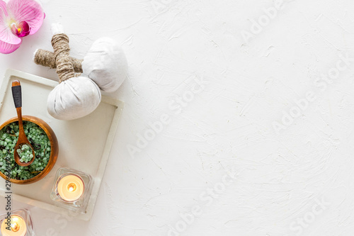 Preparing for massage in spa salon - with candles and orchids - white background top view frame space for text