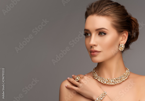 Beautiful girl with set jewelry . Woman in a necklace with a ring, earrings and a bracelet. Beauty and accessories.