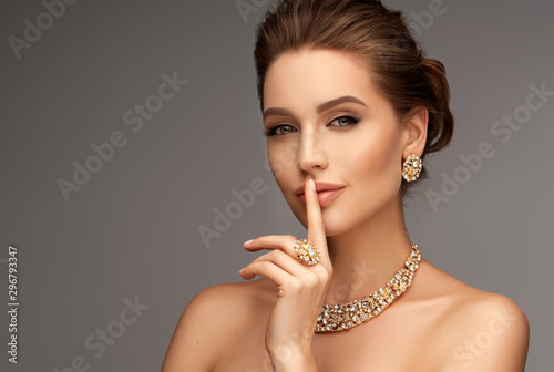 Beautiful girl with set jewelry . Woman in a necklace with a ring, earrings and a bracelet. Beauty and accessories.