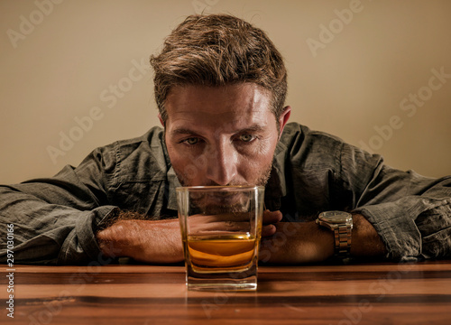 desperate alcoholic man . depressed addict isolated in front of whiskey glass trying not drinking in dramatic expression suffering alcoholism and alcohol addiction problem