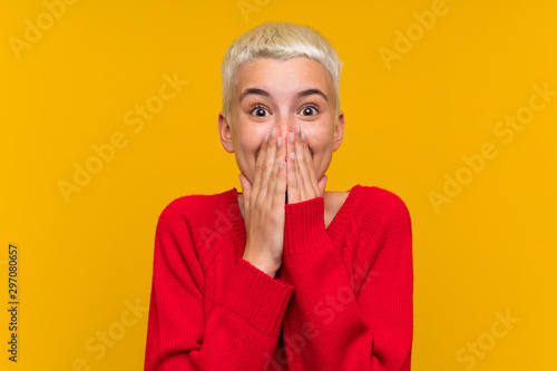 Teenager girl with white short hair over yellow wall with surprise facial expression