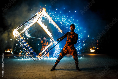 Fire show, dancing with flame, male master fakir with fire works, performance outdoors, flame control man, a man in a suit LED dances with fire, draws a fiery figure in the dark