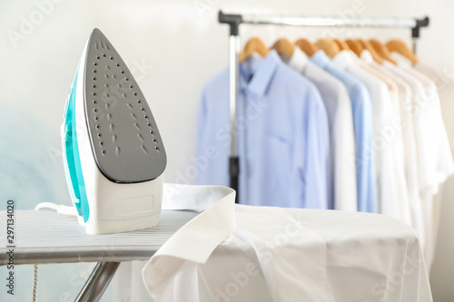 Iron and shirt on ironing board, space for text