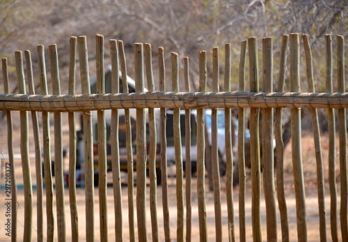 African campers, tents and 4WD vehicles viewed through the wooden tradional kraal fencing