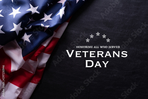 Happy Veterans Day. American flags with the text thank you veterans against a blackboard background. November 11.