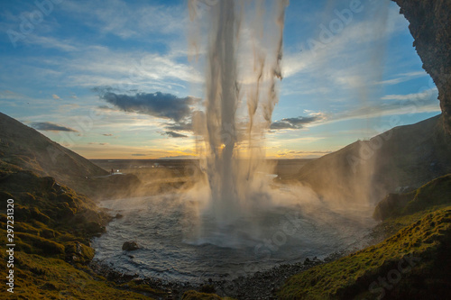 Wodospad Seljalandsfoss (część rzeki Seljalands, która bierze początek w lodowcu wulkanu Eyjafjallajökull) w południowej Islandii, jak widać w godzinie zachodu słońca