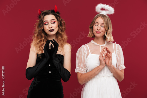 Women angel and demon in carnival costumes