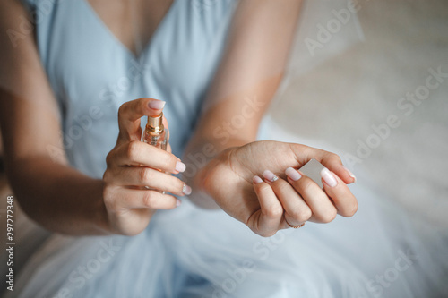 bride applying perfume on her wrist, bright red perfume bottle