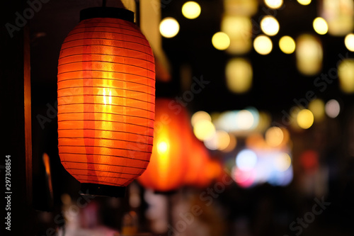 close up many traditional Chinese red lantern at dark night. Colorful blur lights background.