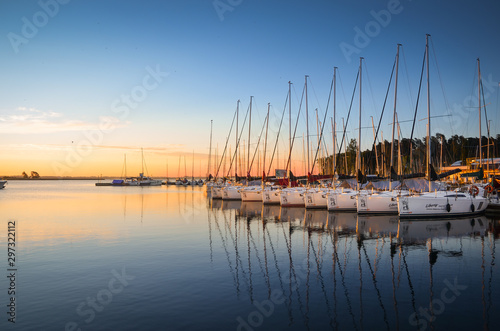 Boats docking in the marina at the Niegocin Lake during sunrise. Wilkasy, Masuria , Poland.